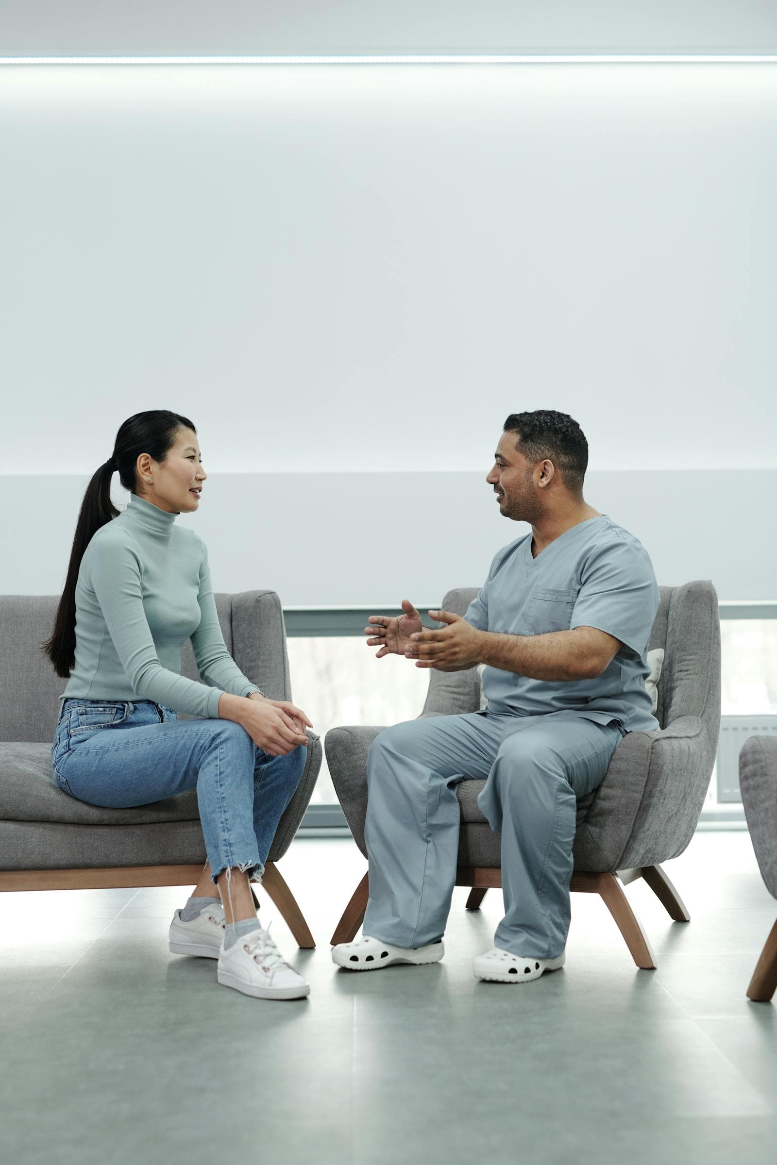 A clinician explaining a treatment plan to an older patient in a calm clinical setting